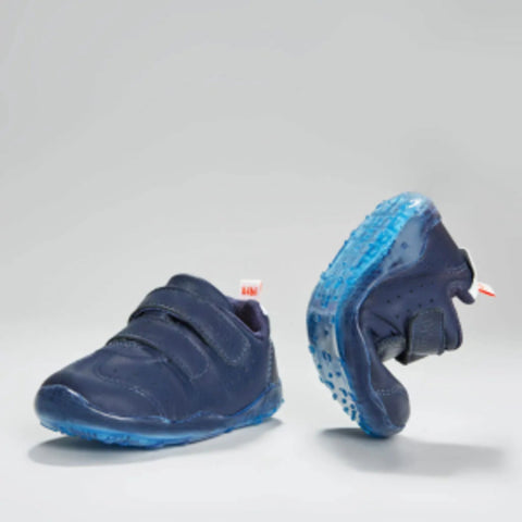 Navy blue children's shoes with blue soles on a light gray background
